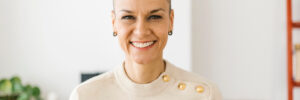 Woman with shaved head smiling into camera